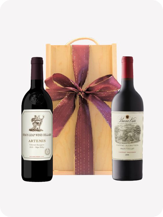 Two red wine bottles in wooden gift box and red ribbon for christmas